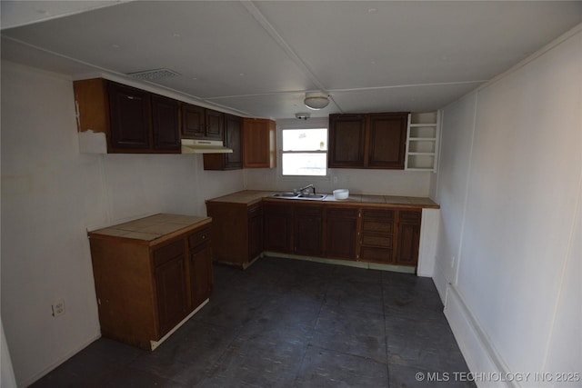 kitchen with open shelves, a sink, under cabinet range hood, and tile countertops