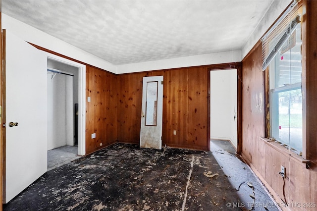 interior space with wooden walls and a textured ceiling