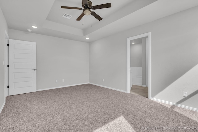 spare room with visible vents, a raised ceiling, baseboards, carpet, and recessed lighting