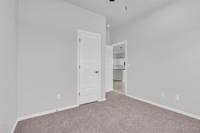 unfurnished bedroom featuring carpet flooring, a ceiling fan, and baseboards