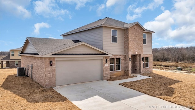 traditional-style home featuring cooling unit, a garage, brick siding, concrete driveway, and roof with shingles