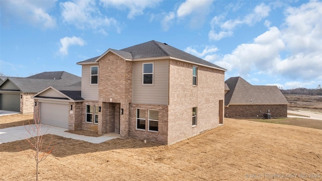 view of front facade with a garage, concrete driveway, roof with shingles, cooling unit, and brick siding