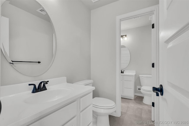 bathroom featuring two vanities, visible vents, a sink, and toilet