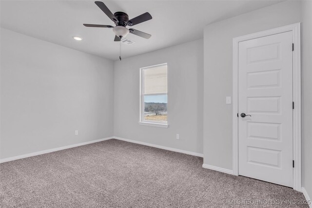 spare room with a ceiling fan, carpet, visible vents, and baseboards