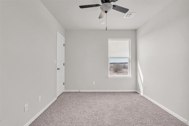 carpeted spare room with a ceiling fan, visible vents, and baseboards