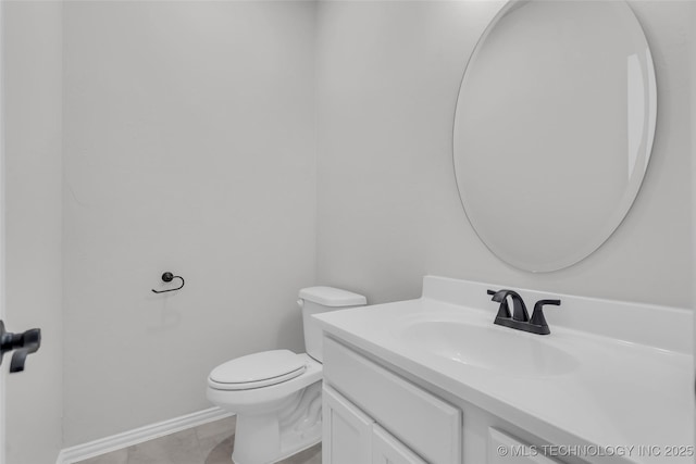 half bathroom featuring toilet, vanity, and baseboards