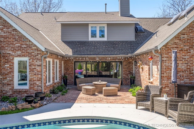 exterior space with brick siding, a patio, an outdoor living space, and roof with shingles