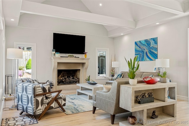 living area featuring lofted ceiling, light wood-type flooring, a fireplace, and recessed lighting