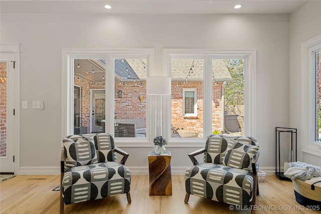 living area with light wood-style flooring, baseboards, and recessed lighting