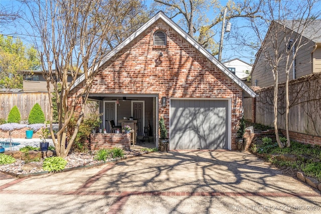 view of front facade featuring driveway, an attached garage, fence, a porch, and brick siding