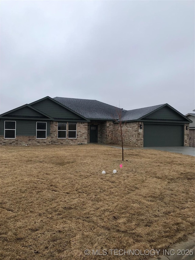 ranch-style house featuring a garage, driveway, a front lawn, and a shingled roof