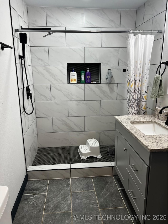 bathroom featuring toilet, a shower stall, and vanity