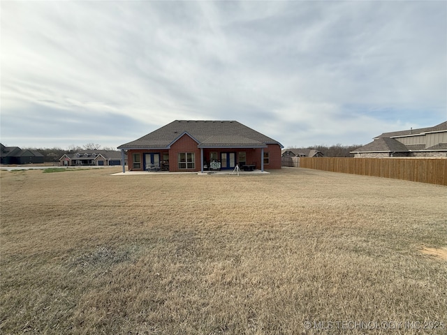1825 E 45th Pl, Sand Springs, OK 74063 - back of property featuring a patio area, fence, and a lawn