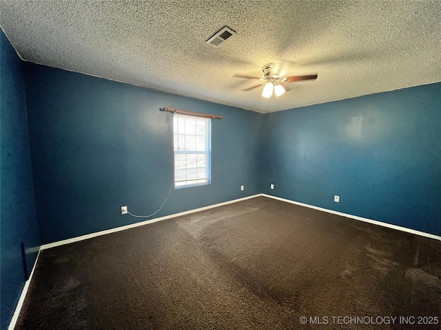 carpeted empty room featuring a textured ceiling, a ceiling fan, visible vents, and baseboards