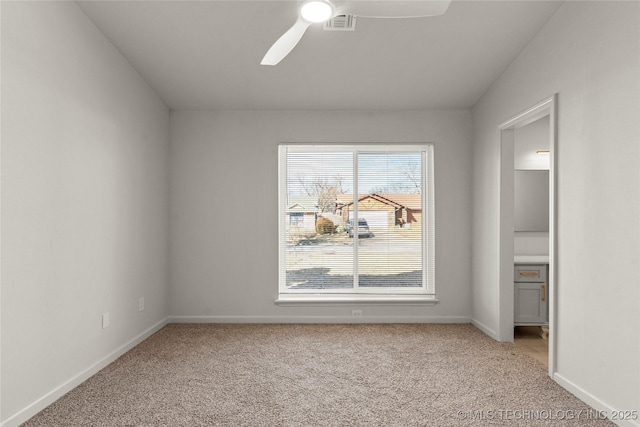 interior space with baseboards, ceiling fan, visible vents, and light colored carpet