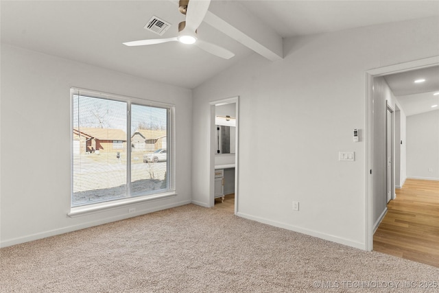 unfurnished bedroom featuring vaulted ceiling with beams, baseboards, visible vents, and light colored carpet