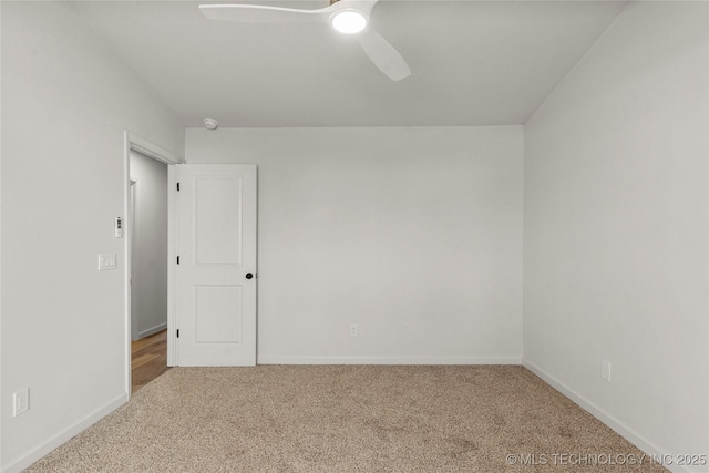 carpeted empty room with ceiling fan and baseboards