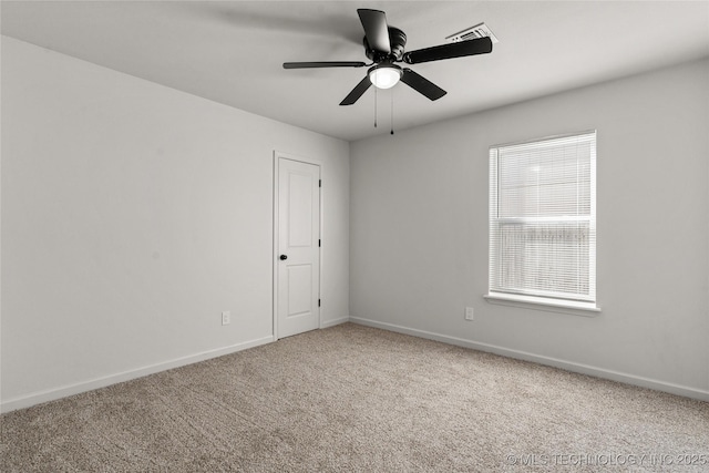 carpeted empty room featuring ceiling fan, visible vents, and baseboards