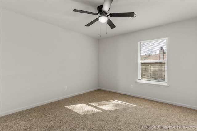 carpeted empty room featuring visible vents, baseboards, and a ceiling fan