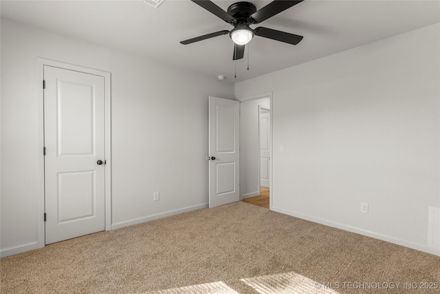 unfurnished bedroom featuring baseboards, a ceiling fan, and light colored carpet