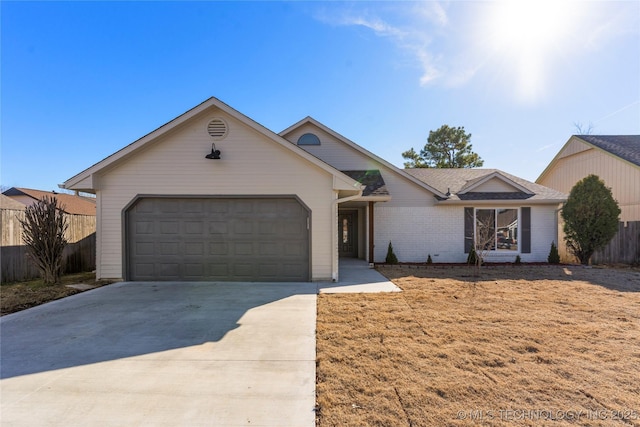 single story home with a garage, driveway, brick siding, and fence