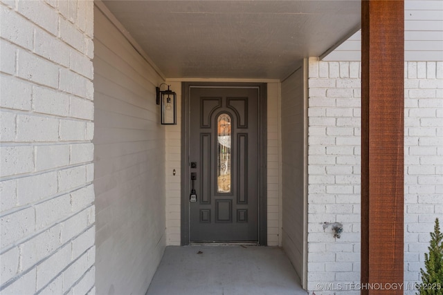 entrance to property featuring brick siding