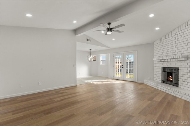 unfurnished living room featuring vaulted ceiling with beams, a fireplace, wood finished floors, a ceiling fan, and baseboards