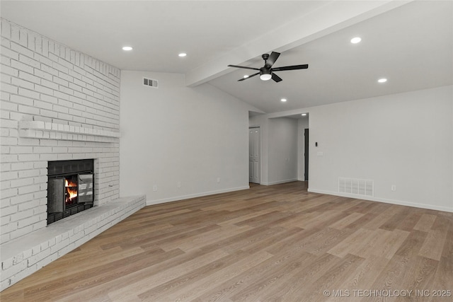 unfurnished living room featuring vaulted ceiling with beams, light wood-style flooring, a fireplace, and visible vents