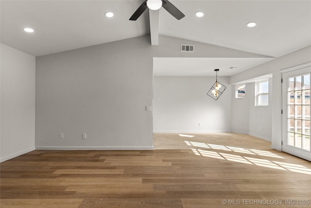 empty room with vaulted ceiling with beams, light wood-style floors, baseboards, and visible vents