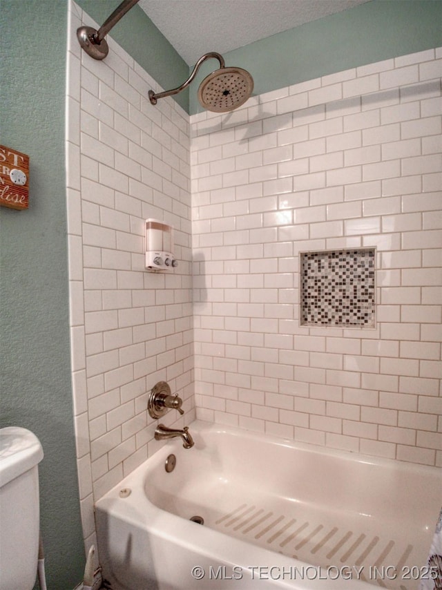 bathroom featuring a textured ceiling, tub / shower combination, and toilet