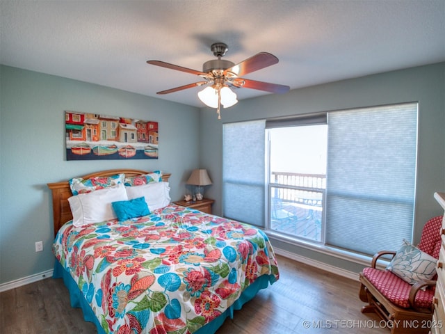 bedroom featuring dark wood-style flooring, ceiling fan, and baseboards