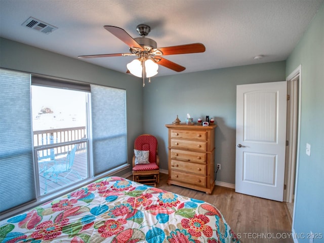 bedroom with baseboards, visible vents, ceiling fan, a textured ceiling, and light wood-type flooring