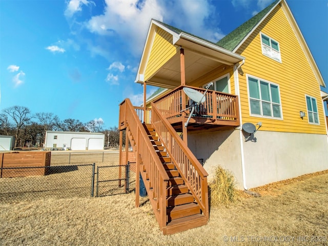 view of playground featuring stairs, fence, and a deck