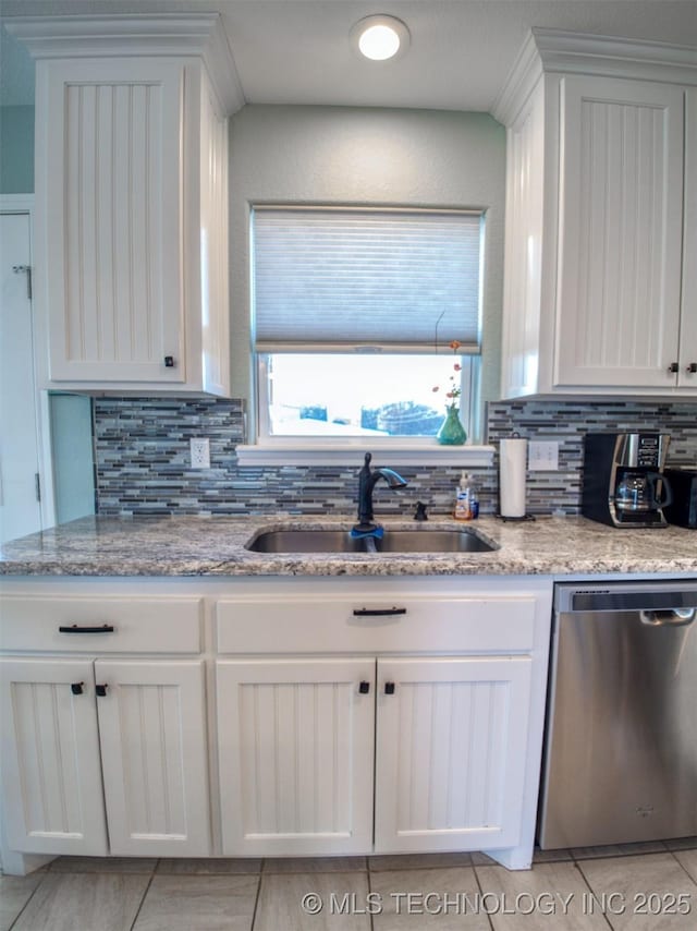 kitchen featuring light stone counters, white cabinetry, dishwasher, and a sink