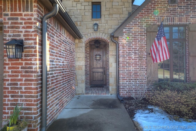 doorway to property with brick siding