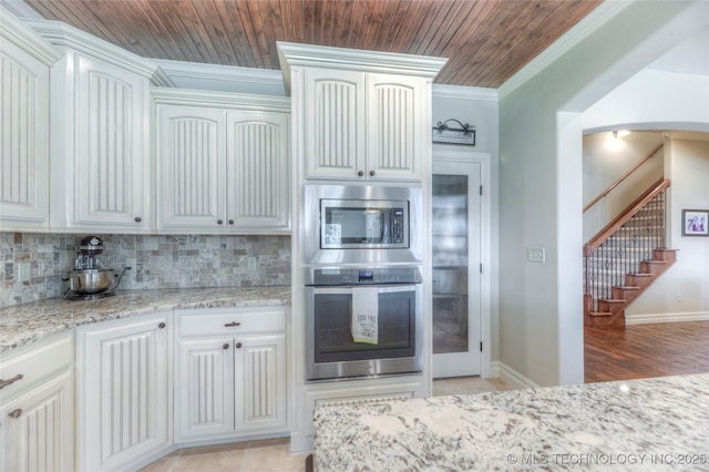 kitchen featuring appliances with stainless steel finishes, white cabinets, and backsplash