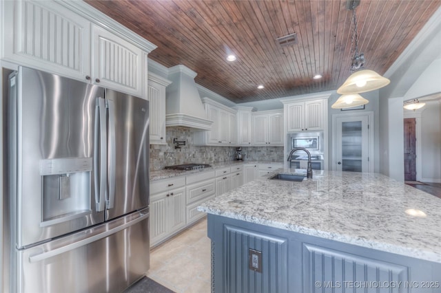 kitchen featuring decorative light fixtures, custom exhaust hood, appliances with stainless steel finishes, white cabinetry, and a sink