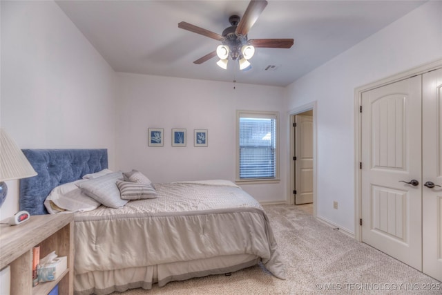 bedroom featuring baseboards, visible vents, light colored carpet, ceiling fan, and a closet