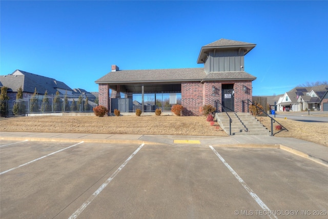 view of property featuring uncovered parking, fence, and a residential view