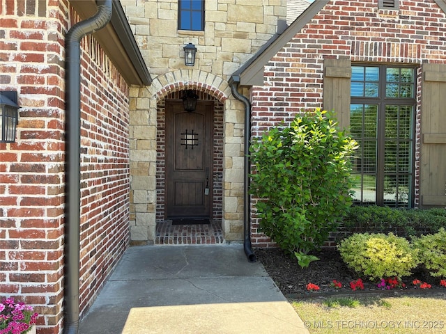 property entrance featuring stone siding and brick siding