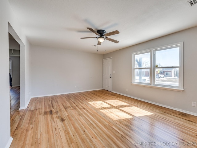 spare room featuring light wood-style floors, baseboards, and visible vents