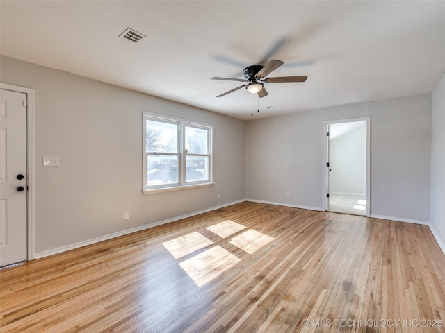 unfurnished room with light wood-style flooring, visible vents, and baseboards