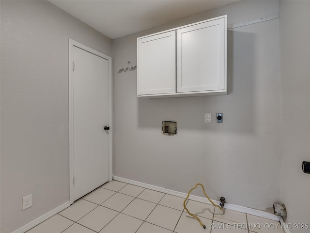 laundry room featuring cabinet space, light tile patterned floors, baseboards, washer hookup, and electric dryer hookup