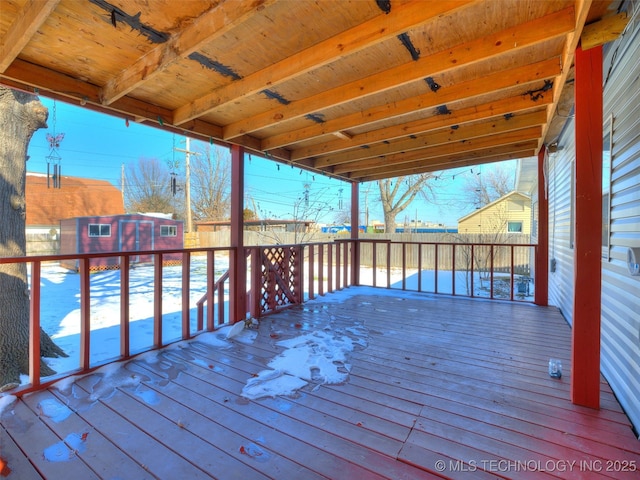 deck with a shed, fence, and an outdoor structure