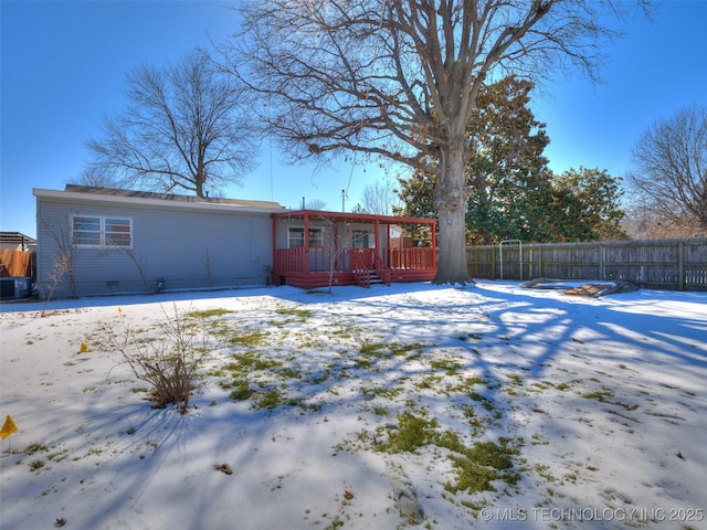 snow covered property featuring crawl space, fence, and a deck