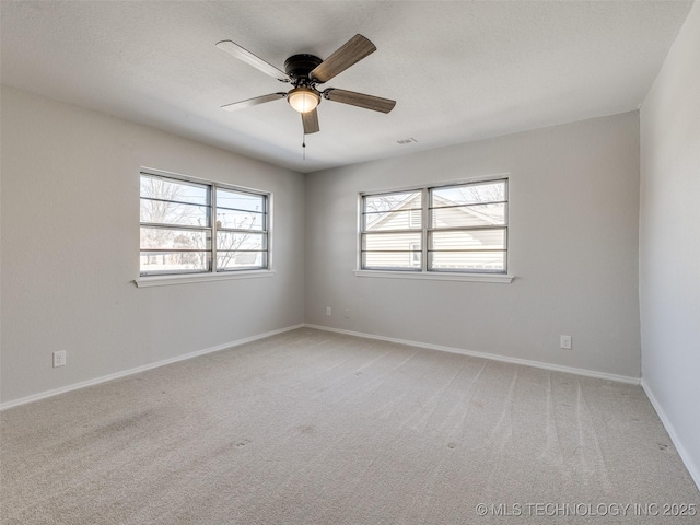 unfurnished room with a textured ceiling, baseboards, a ceiling fan, and light colored carpet