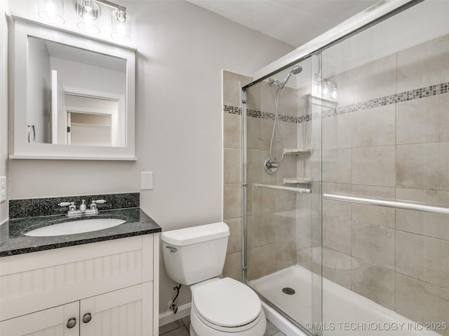 full bath featuring toilet, a stall shower, and vanity