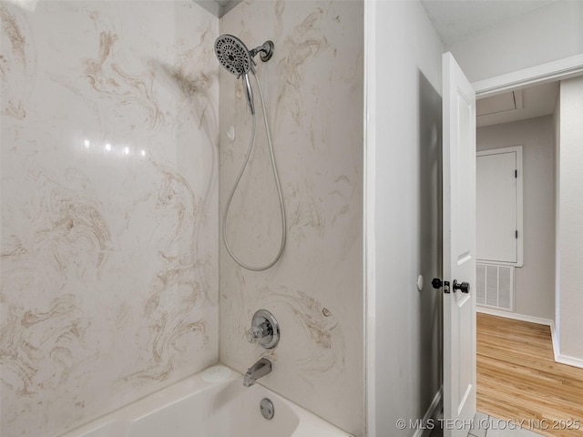 bathroom featuring tub / shower combination, visible vents, and wood finished floors