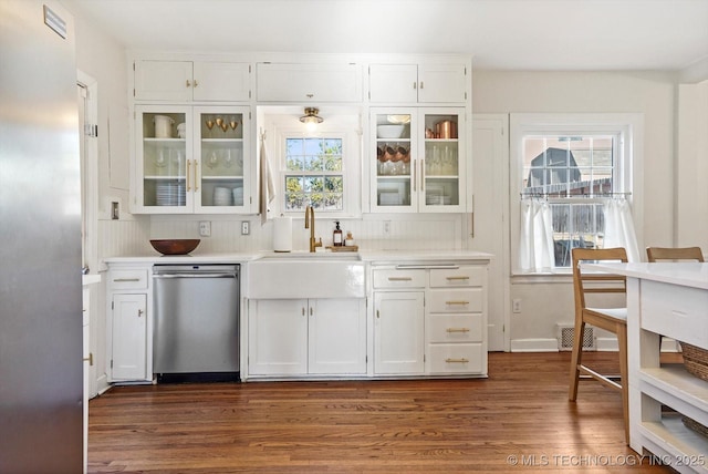 kitchen with light countertops, stainless steel dishwasher, glass insert cabinets, and white cabinetry