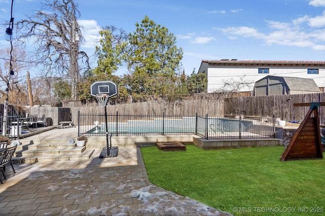 view of sport court with a fenced in pool, a fenced backyard, and a lawn